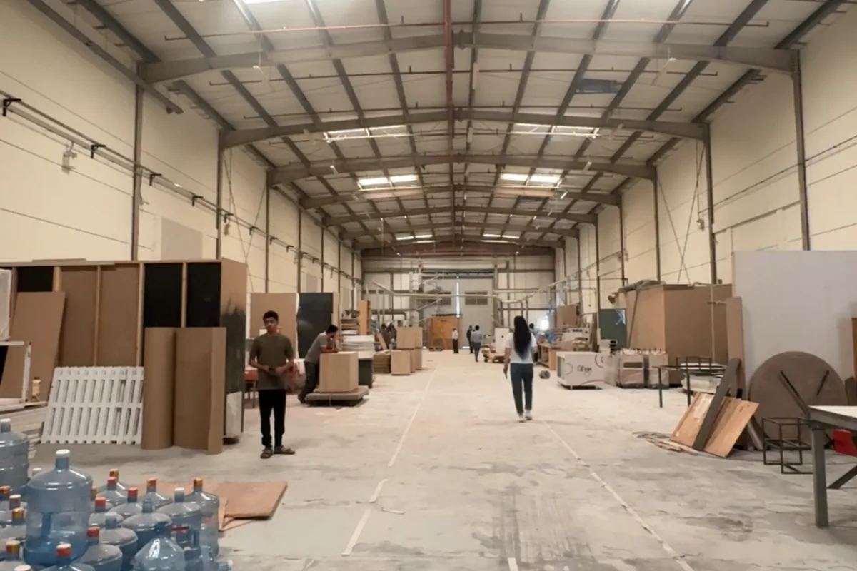 Wide view of the Olympic Furniture production floor at Dubai Industrial City with staff and furniture in production